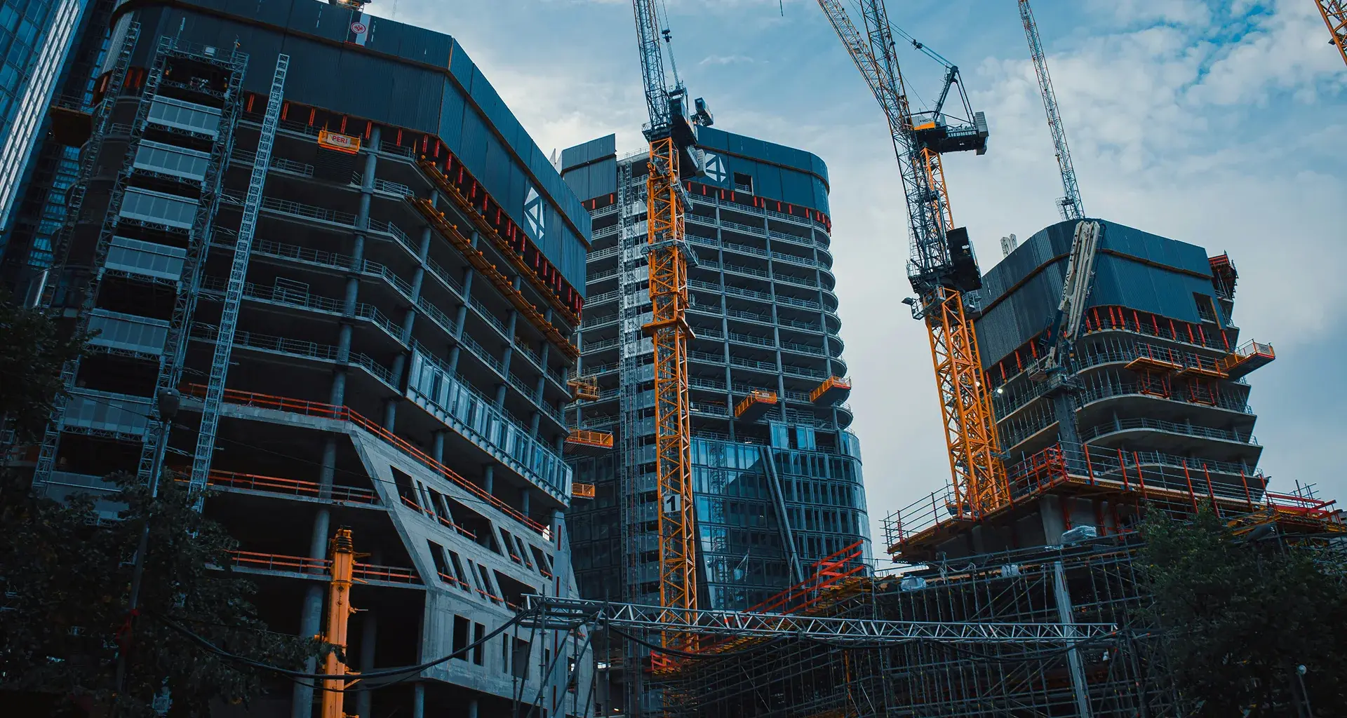 Construction photography of tower cranes over buildings in progress, part of the imagery direction